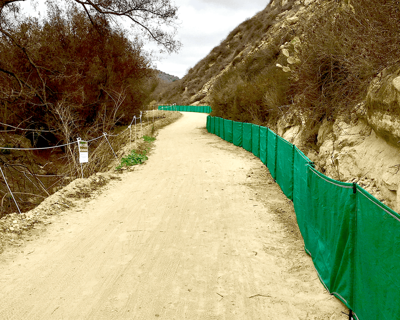 Load image into Gallery viewer, Green evoguard pro 2x100 weather barriers setup next to grassy hill on a road