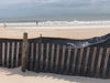 Fence posts and weather barrier in front of a beach