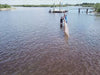 Person setting up a weather barrier in water