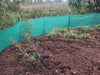 Green weather barrier next to dirt and grass