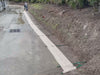 Weather barrier on pavement next to a hill