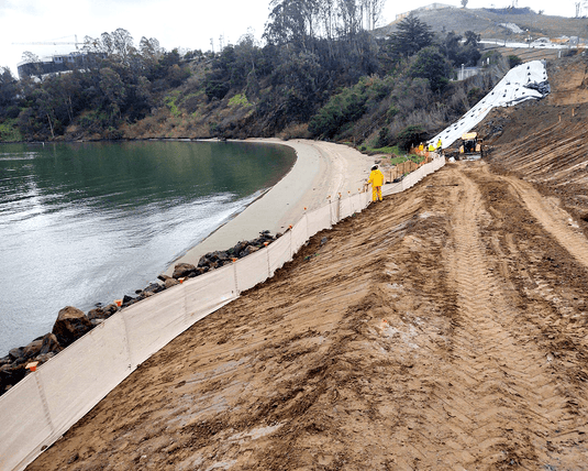 Tan evoguard pro 3x100 weather barrier by a lake and dirt with tire tracks